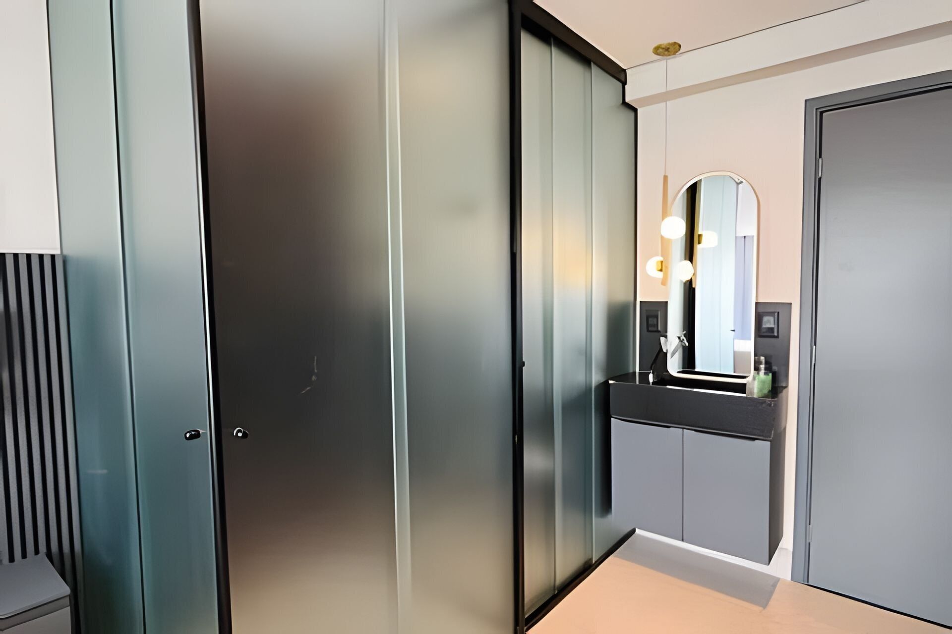A modern bathroom with a mirror, a sink, and a toilet.