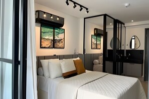 Quarto moderno com cama, um espelho grande e duas obras de arte na parede.