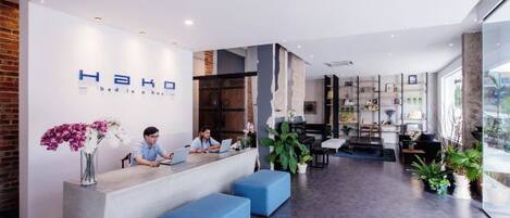 A reception area with a modern design, featuring a reception desk, seating area, and a view of the outdoors.