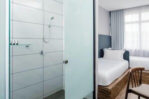 A hotel room with a shower, a bed, a chair, and a window with curtains. - Hako Hotel Tun Aminah (Sekudai)