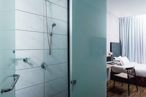 A modern hotel room with a shower, a bed, a desk, and a chair. - Hako Hotel Tun Aminah (Sekudai)
