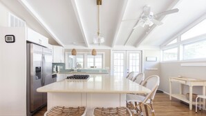 A spacious kitchen with a large island, stainless steel appliances, wicker bar stools, and a ceiling fan. - 1000 FT From Lake Michigan, Hot Tub, Golf Cart (Grand Beach)