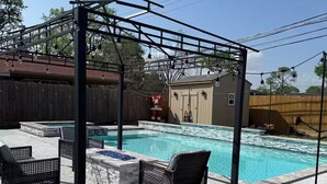 A backyard with a swimming pool, two lounge chairs, a pergola, and a small shed. - Serene 5-bedroom house with AC in vibrant Houston (Houston)