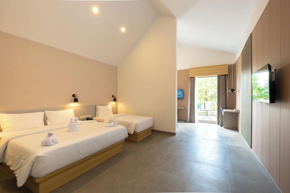 Een hotelkamer met twee bedden, een televisie en uitzicht op de omgeving.