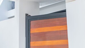 Un edificio moderno con un amplio ventanal de vidrio y una puerta de madera.