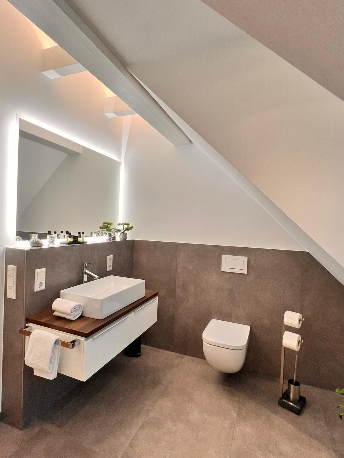A modern bathroom with a freestanding sink, a toilet, and a mirror.