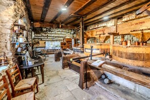 Ein rustikales Interieur mit Steinwänden, Holzmöbeln und verschiedenen Küchengeräten.