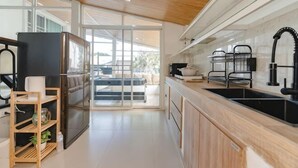 A modern kitchen with a refrigerator, sink, and wooden cabinets. - Springday House Pool Villa Near Nimman (Chiang Mai)