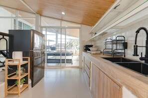 Eine moderne Küche mit Kühlschrank, Spüle und Holzschränken.
