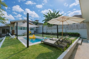 A backyard with a swimming pool, lounge chairs, and a pergola with string lights. - Springday House Pool Villa Near Nimman (Chiang Mai)