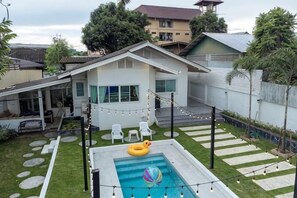 A backyard with a swimming pool, string lights, and a small inflatable pool. - Springday House Pool Villa Near Nimman (Chiang Mai)