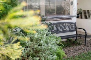 A bench with a decorative backrest, surrounded by greenery and a window with a view. - Springday House Pool Villa Near Nimman (Chiang Mai)