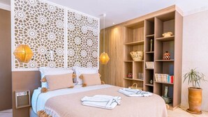 A bedroom with a bed, a bookshelf, and a decorative partition. - SUITE OASIS, 1 bed/1 bath, heated pool (Tamazouzte, Marrakesh-Saf)