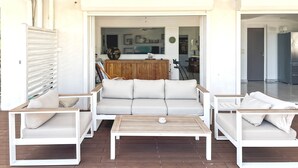 Un espace de vie à aire ouverte avec un plafond en bois, un ensemble de canapés, une table basse et un meuble en bois.