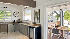 Une cuisine moderne équipée d’un lave-vaisselle, d’un évier et d’un coin repas avec une table et des chaises.