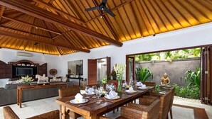 A dining area with a wooden table set for a meal, surrounded by wicker chairs. - The Complete Guide to Renting Your Exclusive Holiday Villa in Kabupaten Badung with Private Pool and Fully Staffed (Bali)