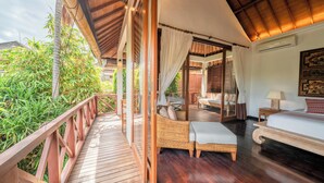 A room with a wooden deck, a bed, a sofa, and a window with curtains. - The Complete Guide to Renting Your Exclusive Holiday Villa in Kabupaten Badung with Private Pool and Fully Staffed (Bali)