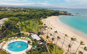 A tropical resort with a swimming pool, beach, and ocean views.
