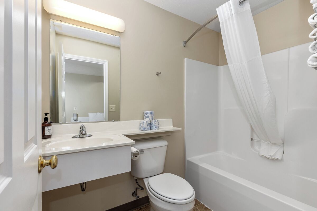 Een badkamer met toilet, wastafel en bad.