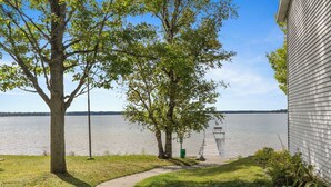 A lakeside property with a dock extending into the water, a pathway leading to the dock, and a building adjacent to the water. - The Lakeview Motel (Lake City)
