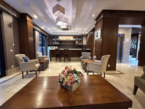 Ein modernes Interieur mit Barbereich, Sitzgelegenheiten und einer floralen Dekoration.