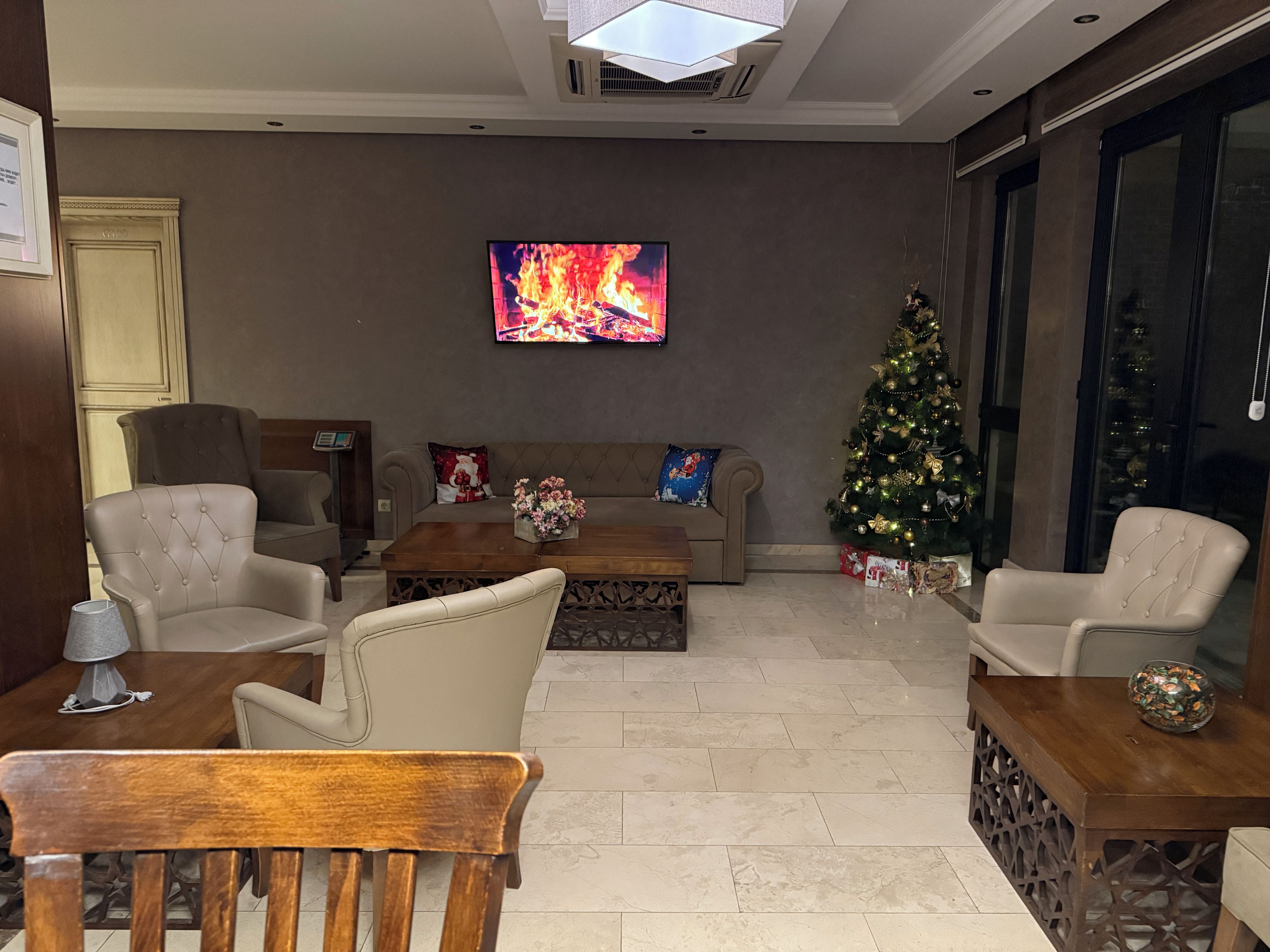 A living room with a television, a Christmas tree, and a sofa.