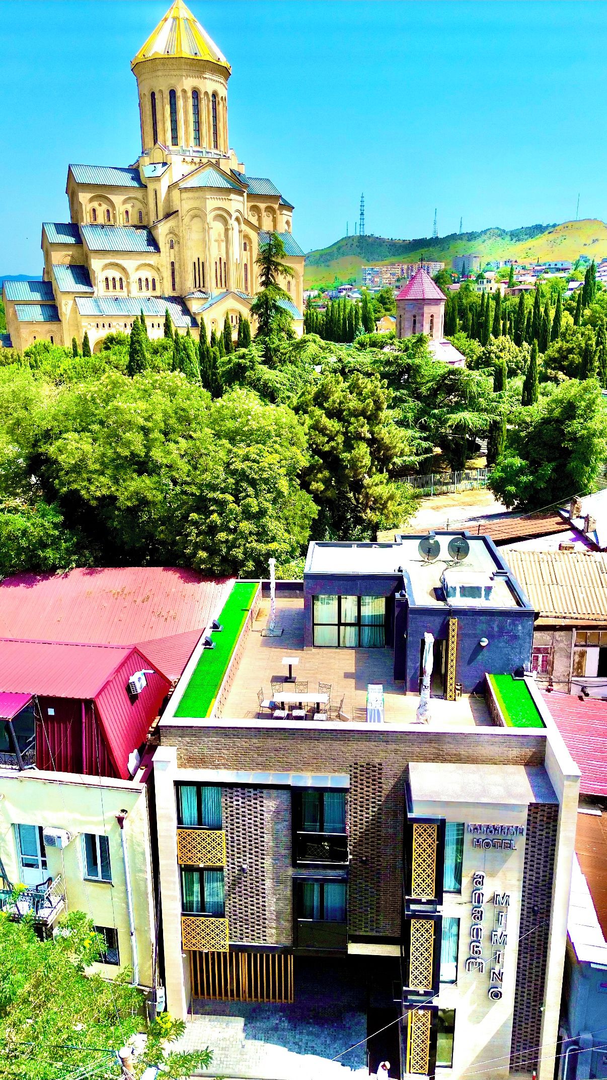 A hotel with a modern design, featuring a rooftop terrace with outdoor seating.
