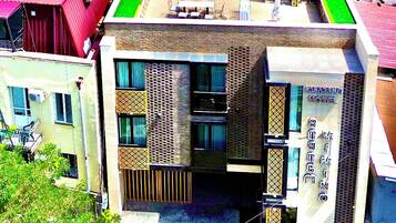A hotel with a modern design, featuring a rooftop terrace with outdoor seating.
