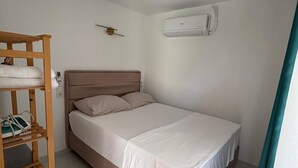 A single bed with a wooden headboard, a small shelf unit, and an air conditioning unit on the wall. - Marmaris apartment with pool (Armutalan)