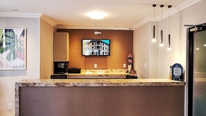 A modern kitchen with a marble countertop, a built-in oven, and a large island.