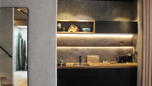A modern kitchen with a wooden countertop, built-in shelves, and a coffee maker.