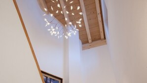 A wooden ceiling with a modern light fixture, a wooden door, and a framed picture on the wall. - Matterhorn Gazes, Luxury Embraces 1000 (Valais)