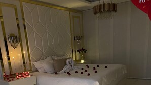 A modern bedroom with a large bed, a nightstand, and a decorative mirror. - hacienda hotel texas (Durania)