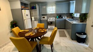 Cozinha compacta com área de jantar, com fogão, micro-ondas e pia.