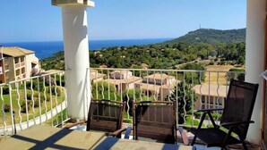 A balcony with two chairs, a view of the sea, and surrounding greenery. - Superb duplex Cap Esterel Sea view (Saint-Raphaël)