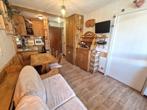 A cozy kitchen with wooden cabinets, a dining table, and a built-in oven.