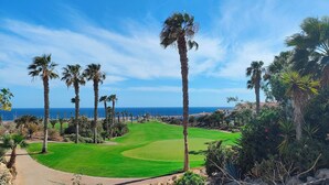 Ein Golfplatz mit freiem Blick auf das Meer und einem Weg zum Abschlagbereich.