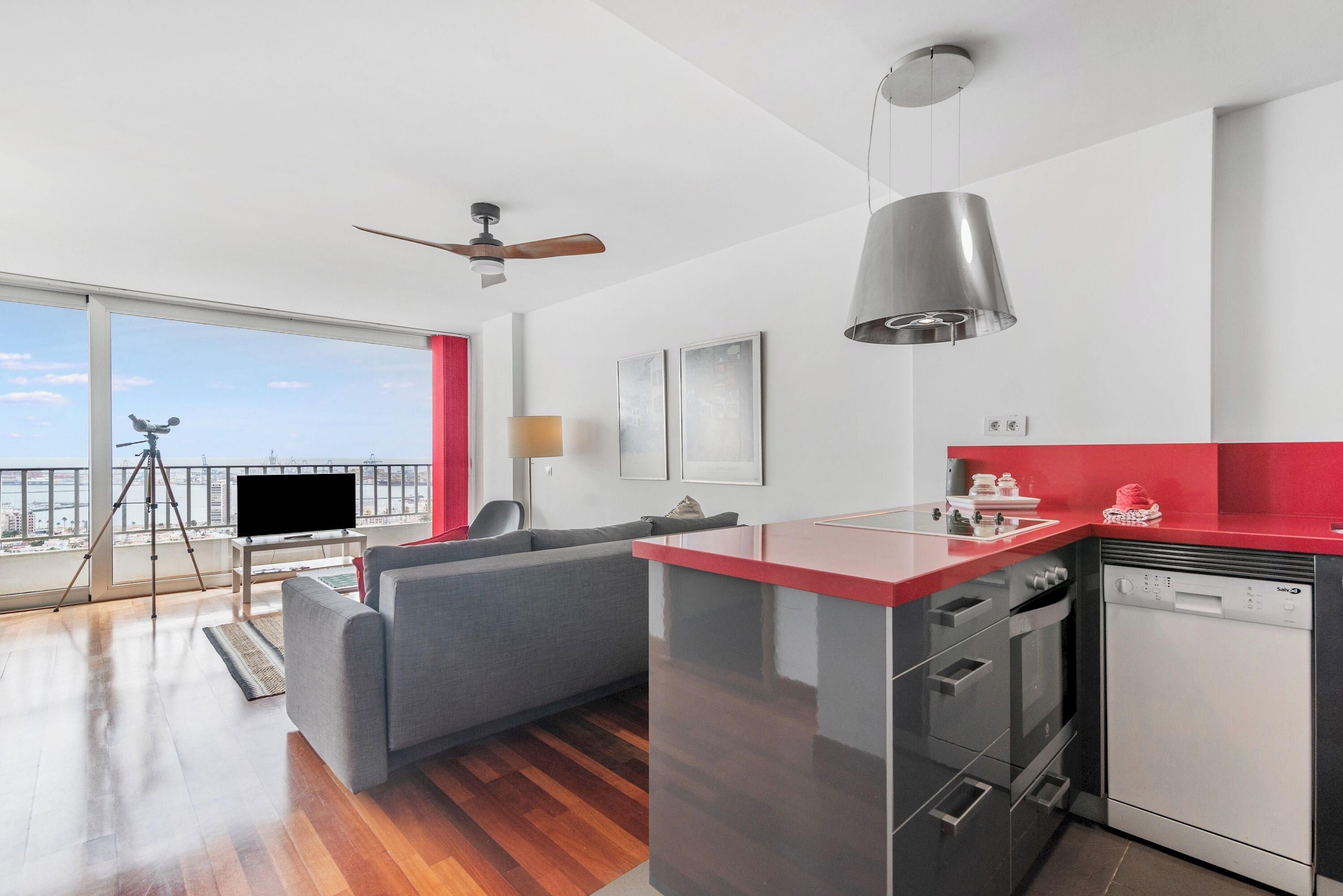 Un apartamento moderno con cocina, sala de estar y balcón con vista a la ciudad.