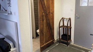 A bathroom with a wooden door, a towel rack, and a shower area. - Studio Alpine Zermatt: Village views & Terrace (Zermatt)