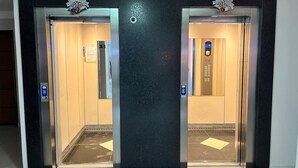 Un ascensor con dos puertas, cada una con un panel de control y una pequeña pantalla.