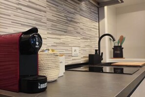 A modern kitchen with a coffee machine, a basket, and a utensil holder. - Design Apartment Loft in Milan Forum (Milan)