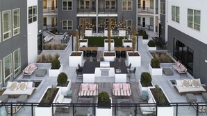 A modern apartment complex with outdoor seating areas, balconies, and a central courtyard. - Parkside Chic 2BR Near Regions Field + Park (Birmingham)