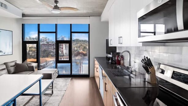 Une cuisine moderne dotée de grandes fenêtres, un coin repas avec vue et un ventilateur de plafond.