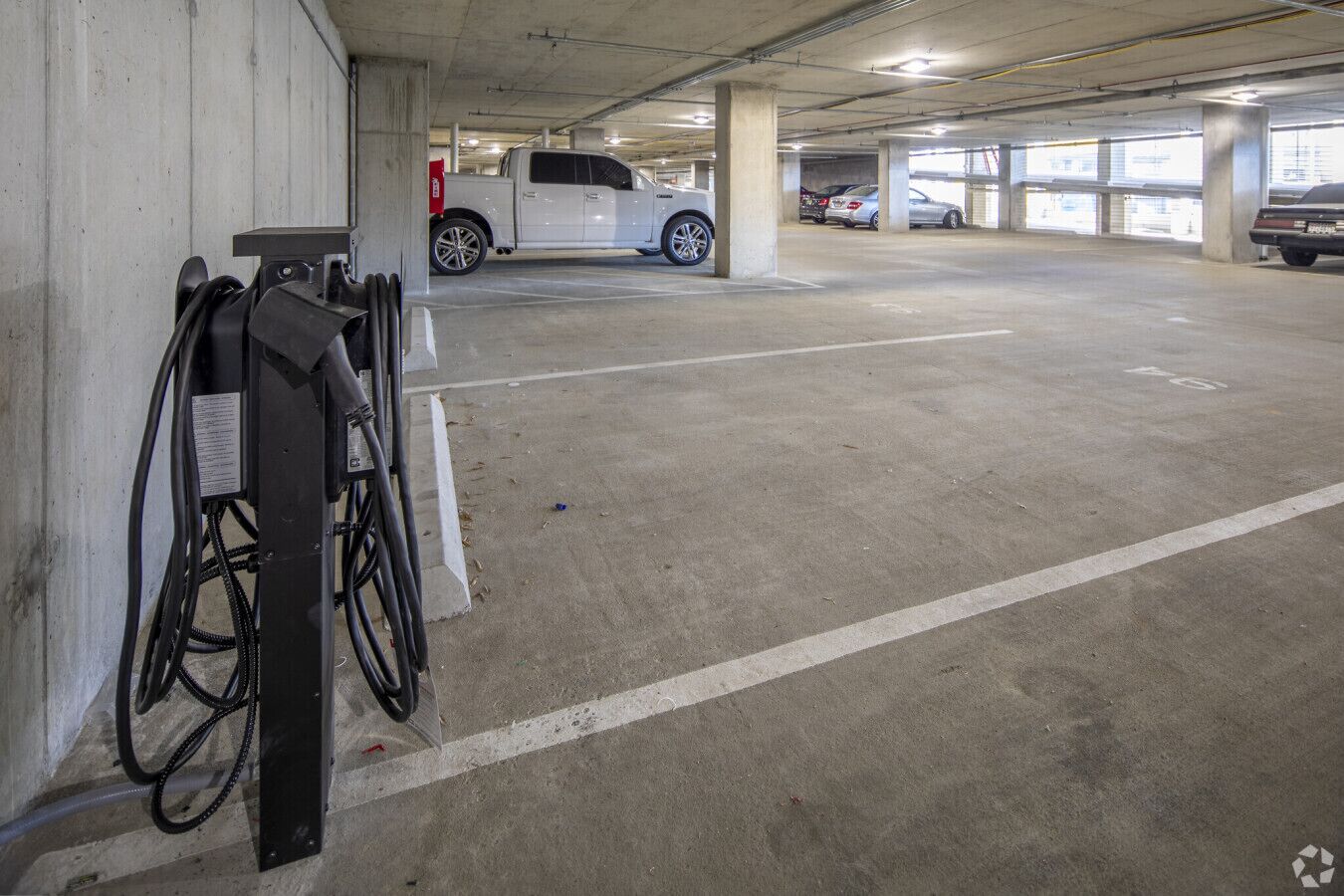 A multi-level parking garage with concrete pillars and marked parking spaces.