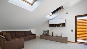 Un salon moderne avec un canapé marron, un meuble en bois et une lucarne.
