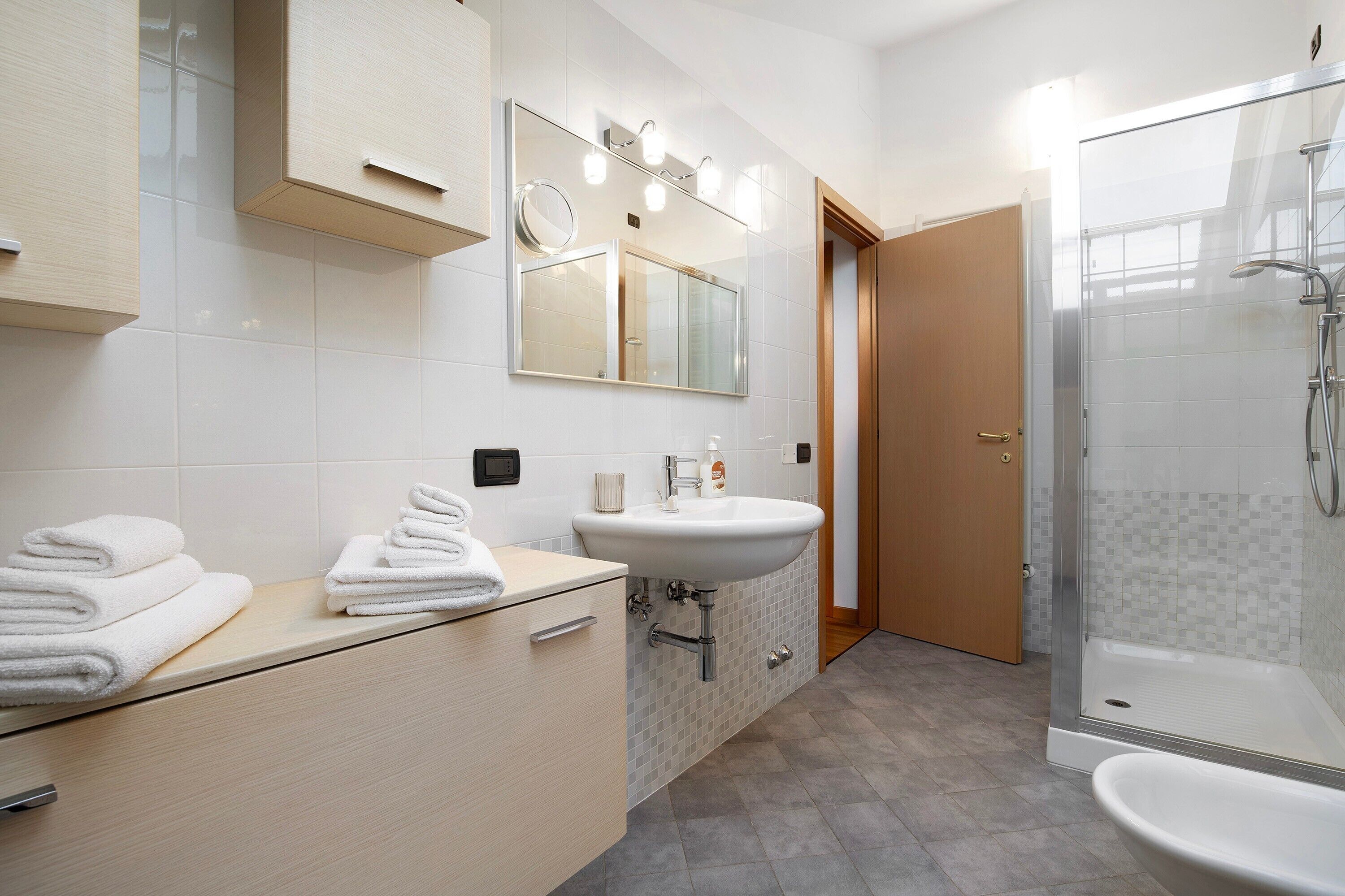 Ein modernes Badezimmer mit Waschbecken, Spiegel und Dusche.