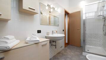 Ein modernes Badezimmer mit Waschbecken, Spiegel und Dusche.