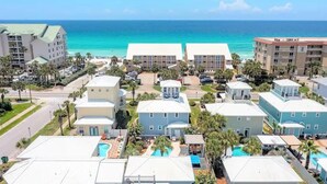 Un hôtel situé en bord de mer, composé de plusieurs bâtiments, doté d’une piscine et offrant une vue sur l’océan.