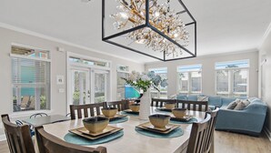 Un coin repas avec une table ronde, des chaises et un lustre décoratif.