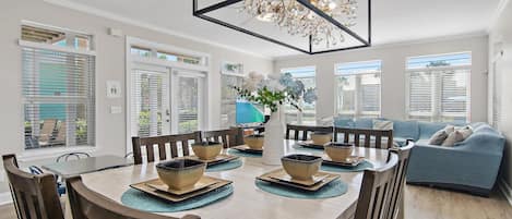 Un comedor con una mesa redonda, sillas y una lámpara decorativa.